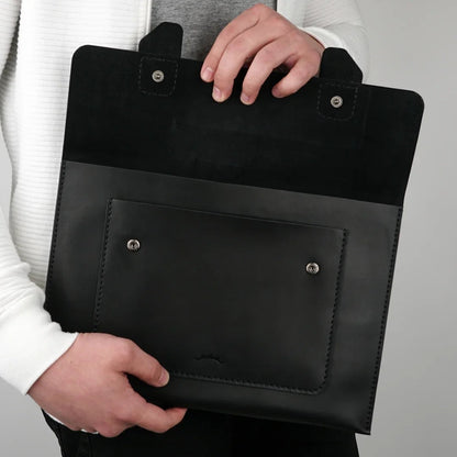 MODISTIAZ black leather document folio with exterior pocket and snap closure. A person holds the folio open.