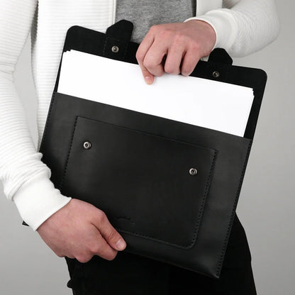 MODISTIAZ black leather document folio with exterior pocket and snap closure, held by a person.